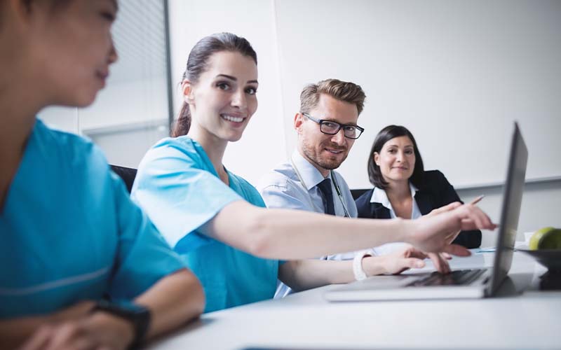 Plusieurs infirmiers souriants autour d'une table